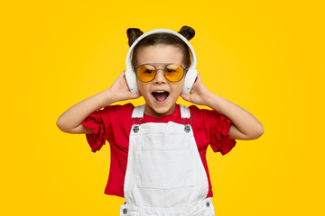 Excited trendy kid listening to music