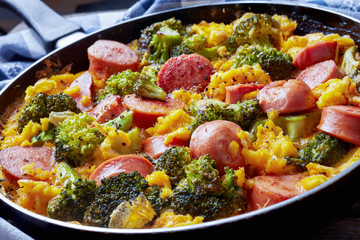 scrambled eggs with broccoli and sausages, closeup