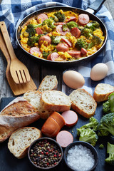scrambled eggs with broccoli and sausages, closeup