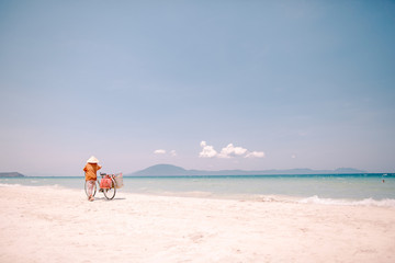 Beach seller in a hat with a bicycle