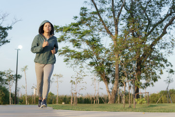 Asian women jogging in the morning garden , healthy lifestyle and sport concept