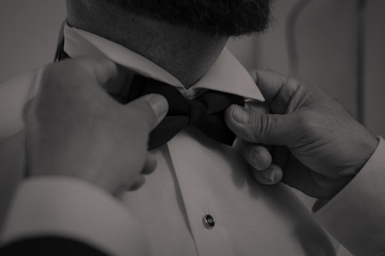 padrino ajustando pajarita a novio