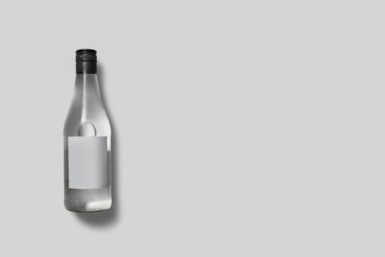Glass bottle with liquid on soft gray background. High resolution photo.