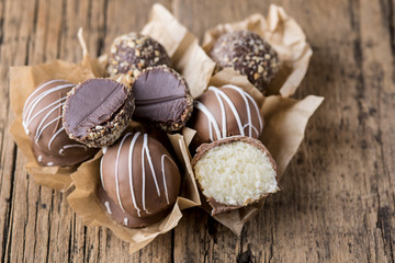 Raw Homemade Vegan Chocolate and Coconut Candies Healthy Vegan Dessert Tasty Chocolate Candies on Old Wooden Background Close Up Horizontal
