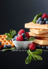 Belgian waffles with  blueberries, raspberries  and fresh mint.