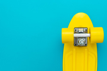 minimalist flat lay photo of cruiser skateboard over turquoise blue background