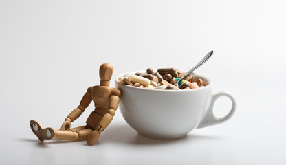 Wooden human dummy near cup full pills and tablets. Vitamin cocktail. Health problem. Immunity care and medicine vitamins. Fast treatment. Mixing medicines. Take medicine concept. Medicines dose