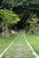 The cement block walk path in the park with green grass.