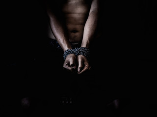 Young man desperate to catch the iron prison,prisoner concept,Handcuffed hands of a prisoner in prison, Male prisoners were severely strained in the dark prison, violence,