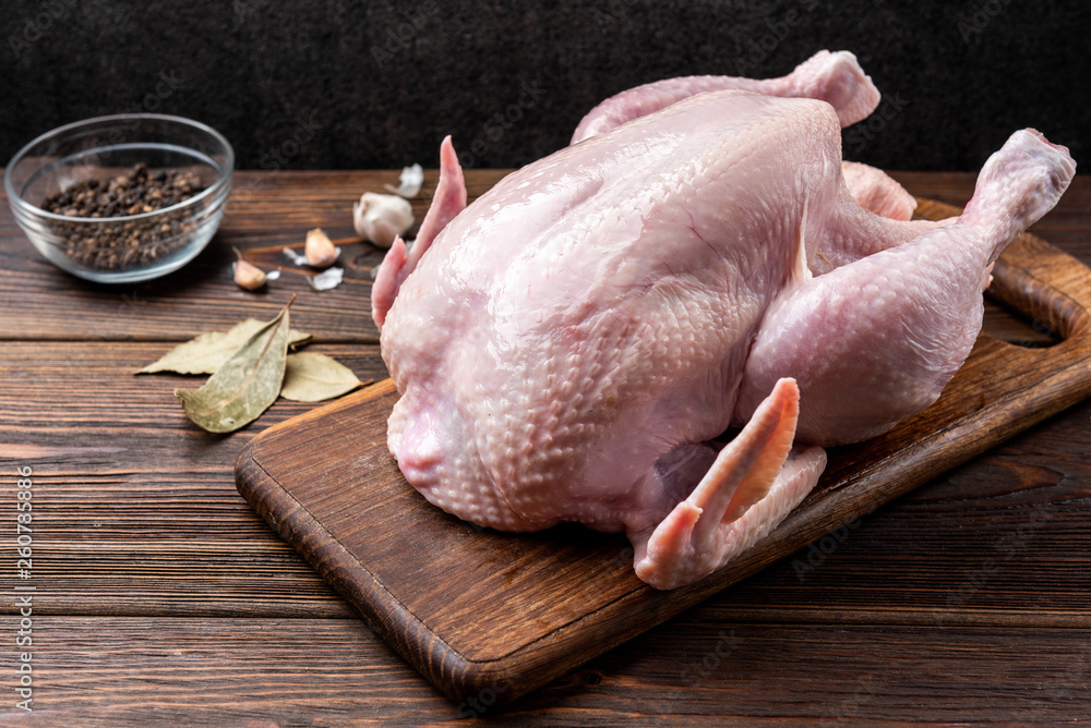 Wall mural raw chicken and spices on dark wooden background.