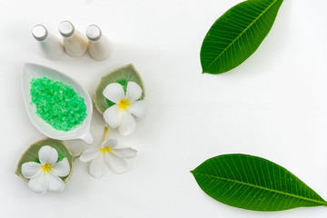 Thai spa composition treatments aroma therapy with candles and Plumeria flowers on white wooden table. Healthy Concept