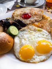 Breakfast with pancakes, jam, eggs, sausages, coffee , juice