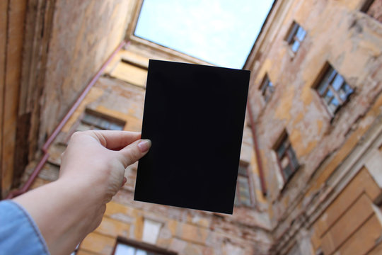 Mock up card, post card or advertising leaflet of standard A5 size on on the background of old houses, old courtyard with yellow dilapidated houses