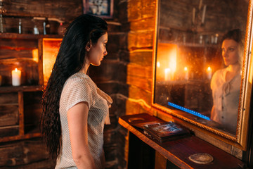 Young woman at the mirror on spiritual seance
