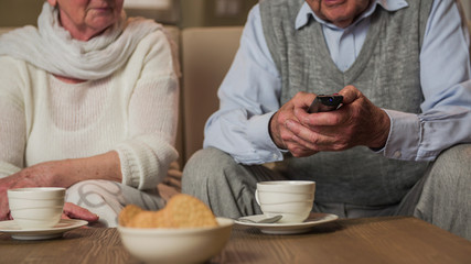 Headless elderly person holding a remote controller