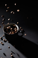 Coffee cup and coffee grains on dark textured surface