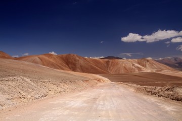 Fototapeta na wymiar Empty dirt road to colorful Copiapo mountains in Atacama desert, Chile