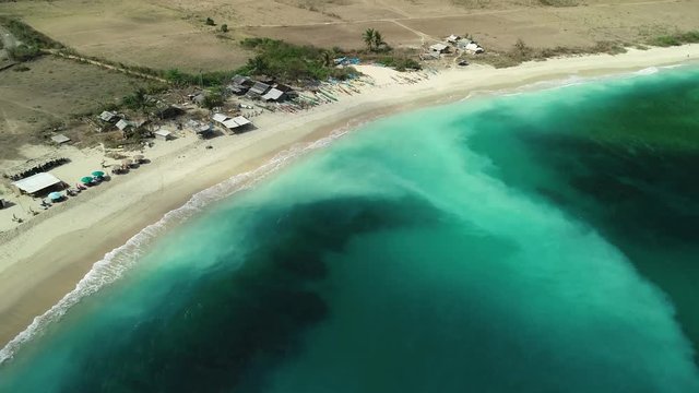 Aerial flying towards Mawun Beach, Bali, Lombok. Secluded turquoise ocean waves for private getaway