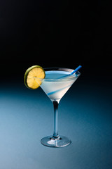 Classic Daiquiri cocktail with lime in martini glass on a dark blue background. Space for text.