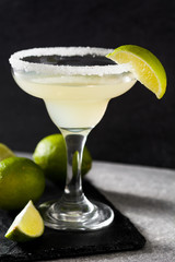 Margarita cocktails with lime in glass on gray background