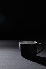 Coffee cup on dark textured surface on black