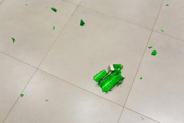 broken wine glass with bottle on wooden table.