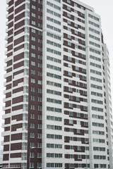 Fototapeta na wymiar Sleeping urban area. Multi-storey residential building with white and brown facade.