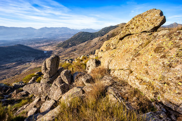 Riscos de granito en la Sierra Paramera y Sierra de Gredos al fondo en un día soleado. Avila. España. Europa.