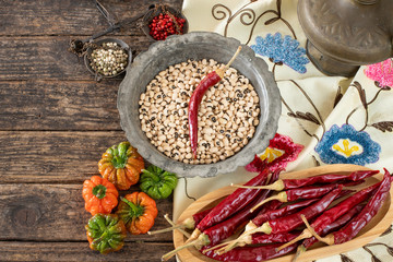 Legumes in the bowl and in the copper cookware on the rustic wooden table