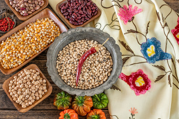 Legumes in the bowl and in the copper cookware on the rustic wooden table