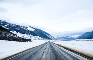 The road in the snow-capped mountains . Winter landscape. 