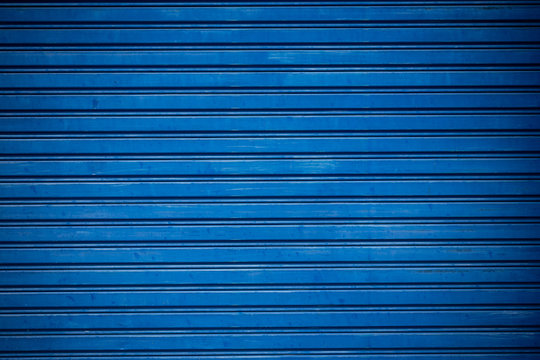 Old blue shuttered roll up metal door.
