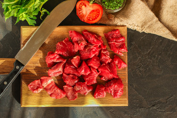 raw meat sliced, cut pieces on a cutting board, fresh. top view. food background