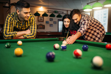 Billiard players with cues, friends in poolroom
