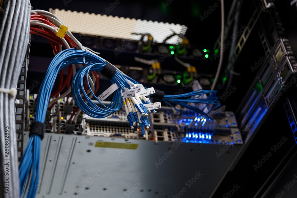 Poster close up twisted internet wires or patch cord optic on blurred background. technical equipment for c