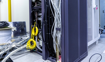 Racks with servers, computer equipment and connected twisting and coiling internet wires