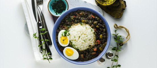 banner of rice with black beans and boiled egg on the table with spices and olive oil. healthy caribbean food