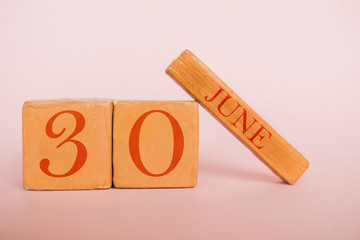 june 30th. Day 30 of month, handmade wood calendar  on modern color background. summer month, day of the year concept
