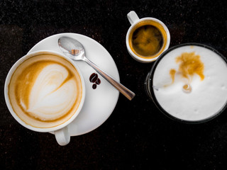 Coffee latte, black espresso and cappuccino coffee with whipped cream on black table