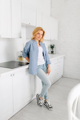 Woman standing on kitchen with snow-white interior