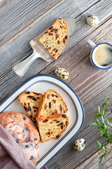 Easter Bread (Osterbrot in German). Top view of traditional fruity bread on rustic wood  with fresh leaves and quail eggs