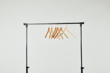 Obraz premium Steel straight rack with wooden hangers isolated on grey