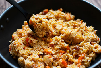 Traditional homemade Uzbek pilaf or plov in iron frying pan. Uzbek cuisine. Close Up. Selective Focus.