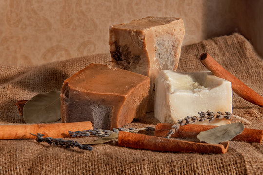 Handmade soap on the napkin with cinnamon, laurel, chamomile, anise, star anise, rosemary, thyme, oatmeal, lavanta