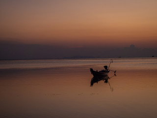 Silhouette of a boat on the background of the setting sun with clouds. Koh Phangan Thailand