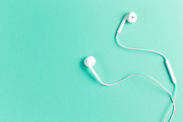 Headphones on Mint background. White headphones on a Mint background. Top view. Flat lay. Copy...
