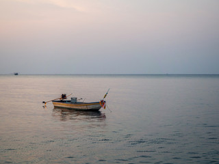 Naklejka premium Silhouette of a boat on the background of the setting sun with clouds. Koh Phangan Thailand
