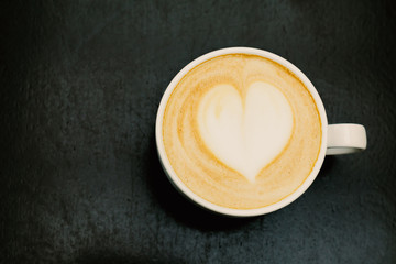 top viewof big cup of freshly brewed cappuccino with soft foam and heart on wooden table.