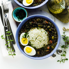 rice with black beans and boiled egg on the table with spices and olive oil. healthy caribbean food