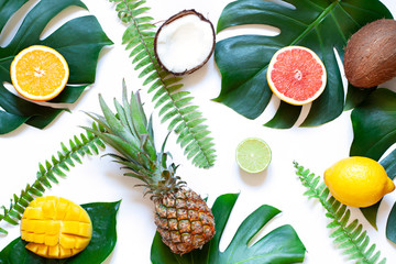 Tropical leaves and fruits summer concept flat lay on the white background. 
